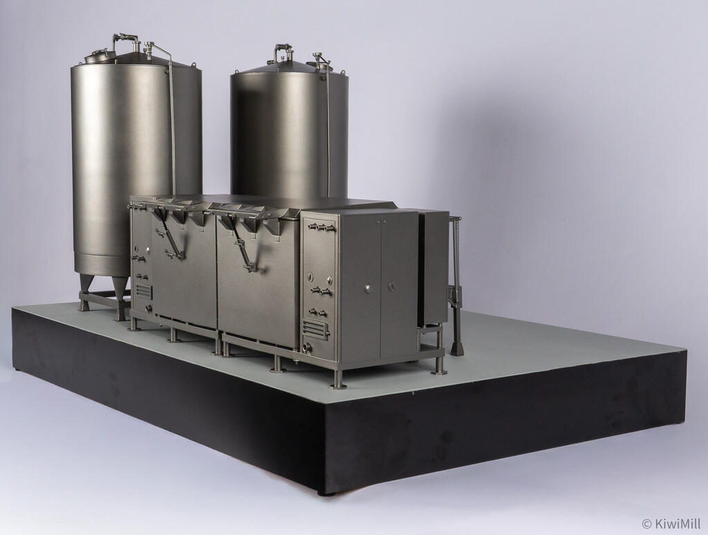 Low rear angle of the cook tank model with hinge linkages on each tank wall and water tanks rising behind